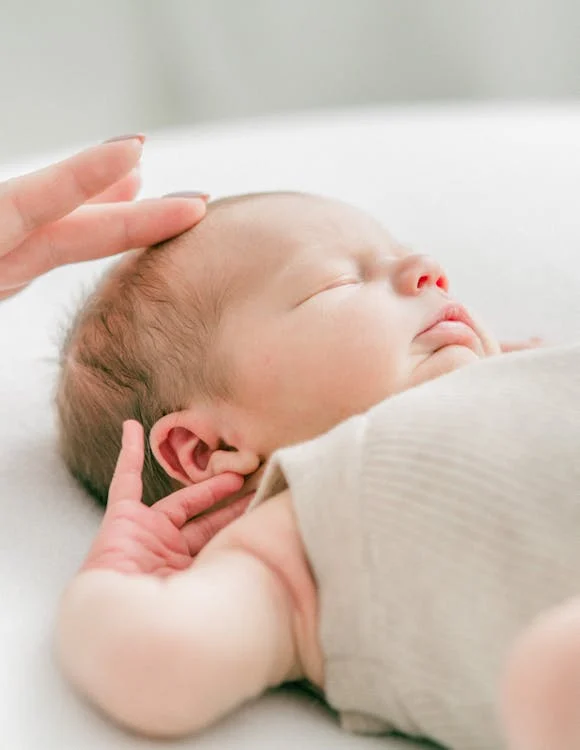 Parent checking if baby sweating in sleep is normal or a sign for concern.