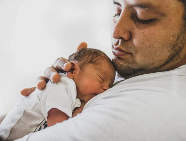 Parent gently soothing a newborn who won't sleep using calming techniques.